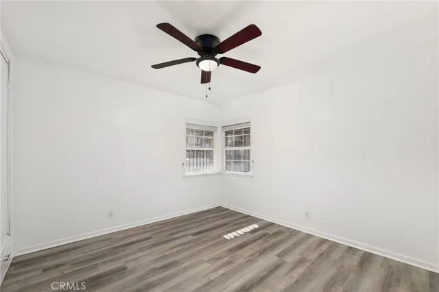 an empty room with a ceiling fan and window