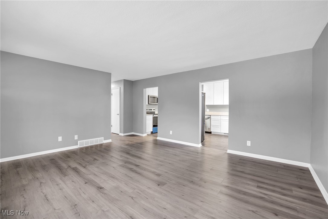 3930 Wadsworth Road Barberton, OH 44203 - Photo 16 of 30 Unfurnished living room featuring baseboards and light wood finished floors