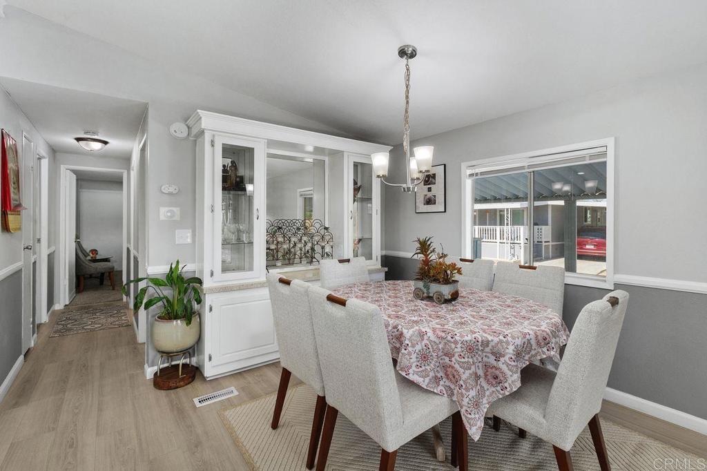 530 West Devonshire Avenue, Unit 84 Hemet, CA 92543 - Photo 13 of 36 a dining room with furniture wooden floor a chandelier and a rug