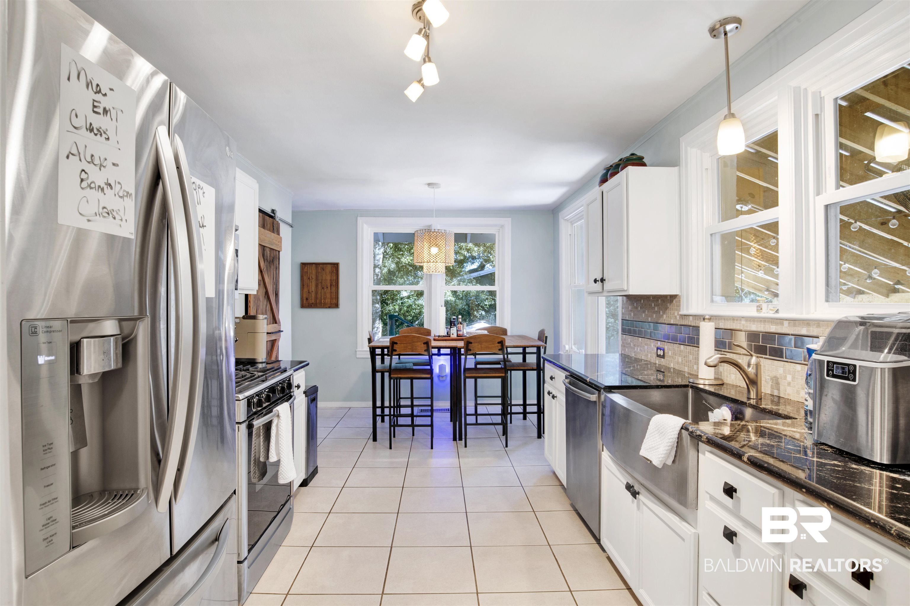 605 Van Avenue Daphne, AL 36526 - Photo 13 of 37 Kitchen with stainless steel appliances, a barn door, pendant lighting, light tile patterned floors, and white cabinets