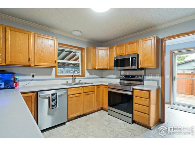 a kitchen with stainless steel appliances granite countertop a stove top oven a sink dishwasher a dining table and chairs with wooden floor