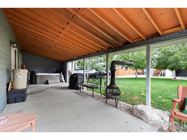 a view of a backyard with table and chairs under an umbrella