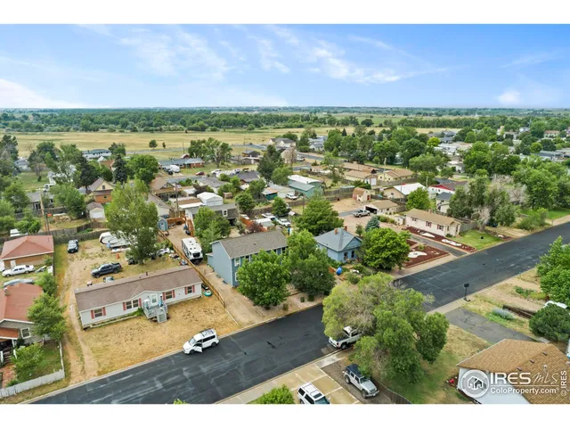 an aerial view of residential houses with outdoor space and trees