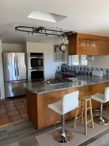 a metallic refrigerator freezer sitting in a kitchen