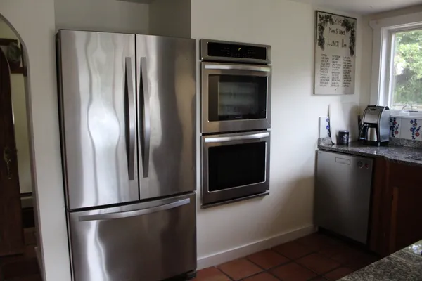 a kitchen with granite countertop a sink stainless steel appliances and cabinets