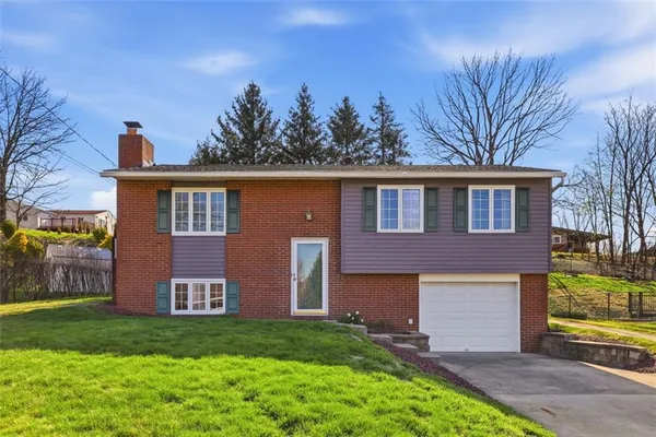 a front view of a house with a garden and yard
