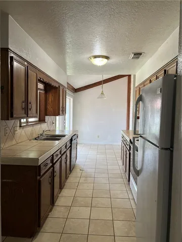 a kitchen with stainless steel appliances granite countertop a sink and a refrigerator