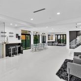 a living room with furniture a table and kitchen view