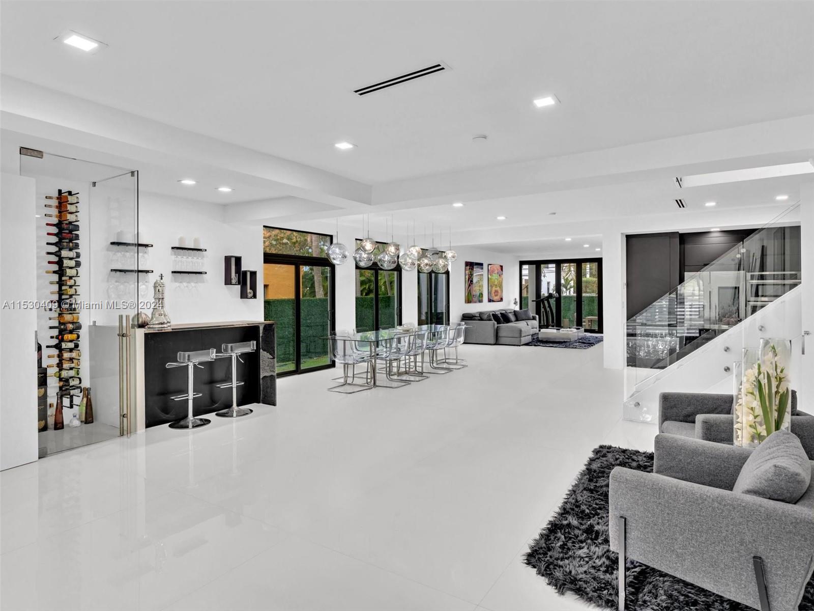 a living room with furniture a table and kitchen view