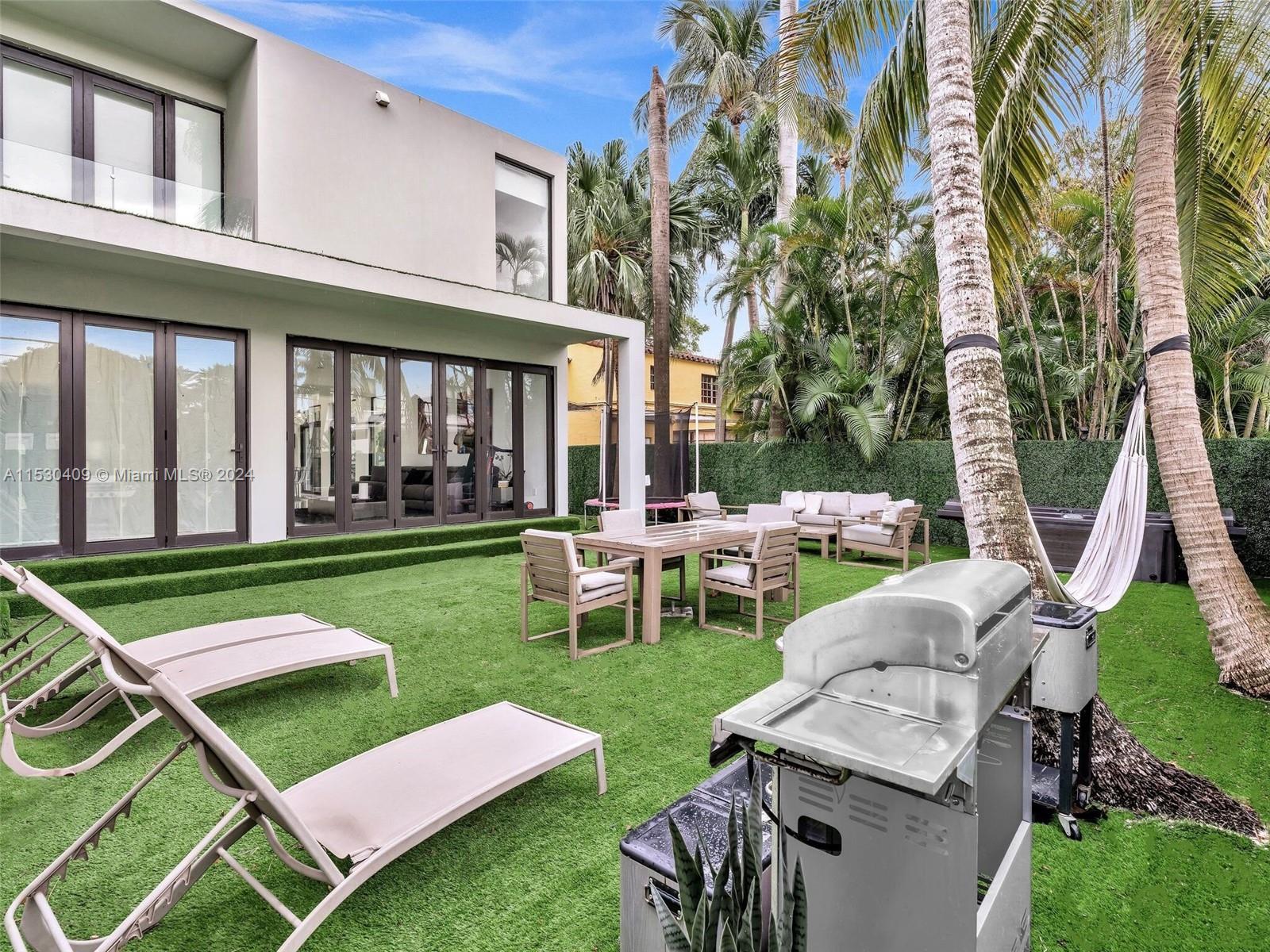 3010 Alton Road Miami Beach, FL 33140 - Photo 15 of 41 a view of a patio with couches chairs and a yard