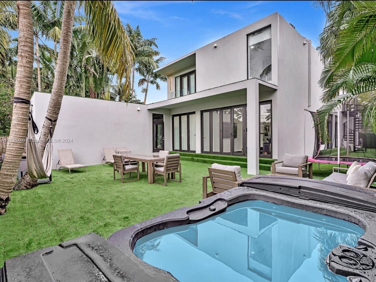 3010 Alton Road Miami Beach, FL 33140 - Photo 17 of 41 a view of a house with backyard swimming pool and sitting area