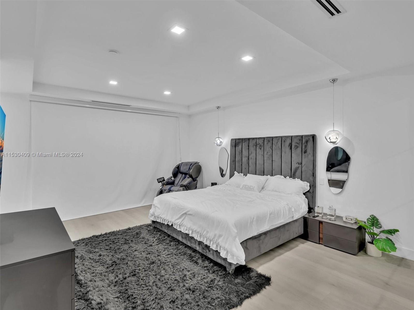 3010 Alton Road Miami Beach, FL 33140 - Photo 24 of 41 a bedroom with a bed and a dresser with wooden floor