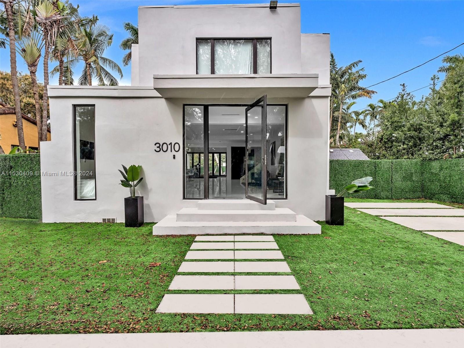 3010 Alton Road Miami Beach, FL 33140 - Photo 5 of 41 a front view of a house with a yard and potted plants