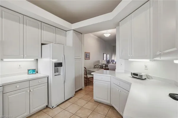 a kitchen with white cabinets and white appliances