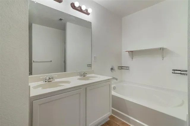 a bathroom with a tub sink and mirror