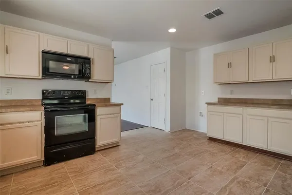 a kitchen with granite countertop a stove and a microwave