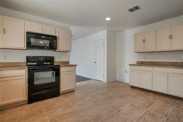 a kitchen with granite countertop a stove and a microwave