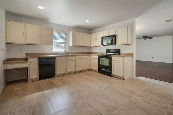 a kitchen with stainless steel appliances granite countertop a stove top oven a sink dishwasher and a refrigerator