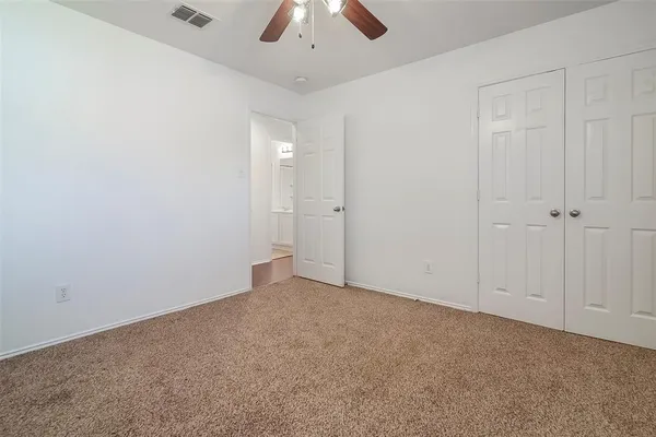 an empty room with chandelier fan
