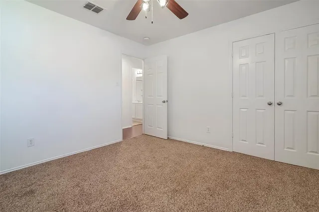 an empty room with chandelier fan