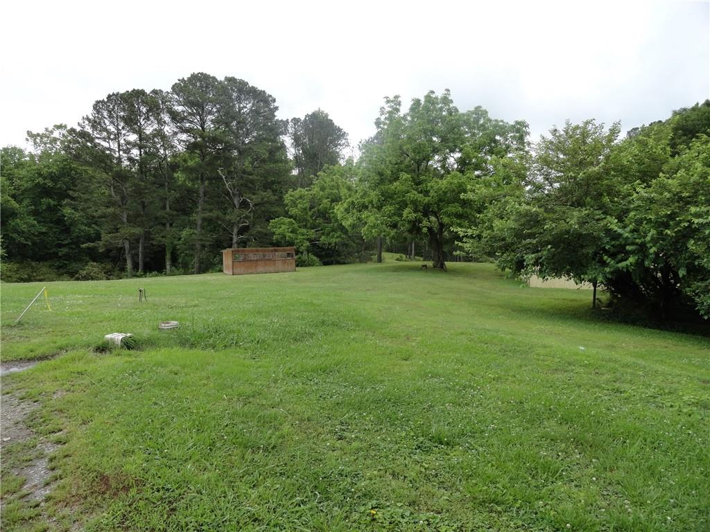 8664 Cumming Highway Canton, GA 30115 - Photo 6 of 18 a view of a green field with trees in the background