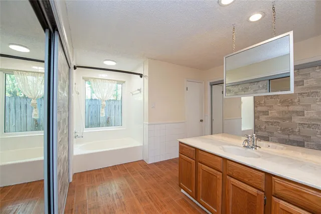 a bathroom with a sink mirror vanity and bathtub