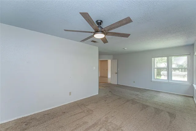 a view of a livingroom with a ceiling fan and window