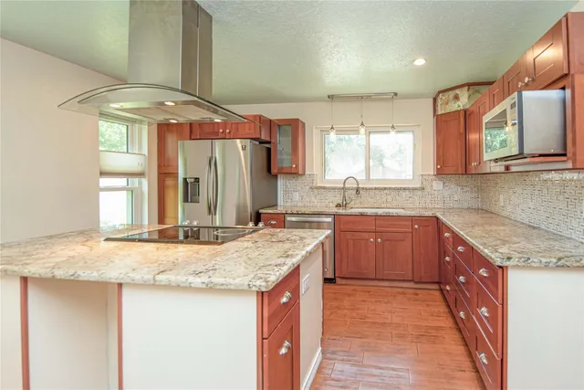 a kitchen with granite countertop a sink and a stove