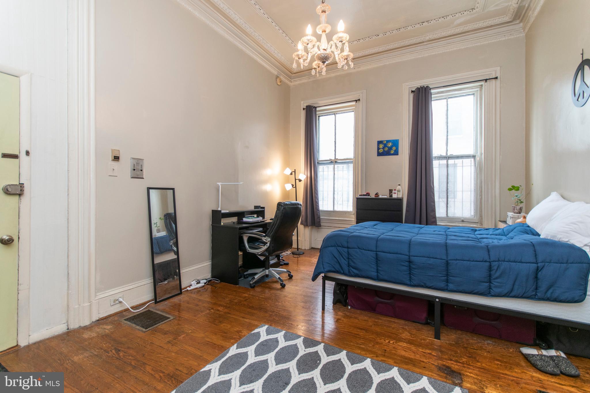 1807 Spruce Street, Unit 1F Philadelphia, PA 19103 - Photo 2 of 12 a bedroom with a bed and wooden floor