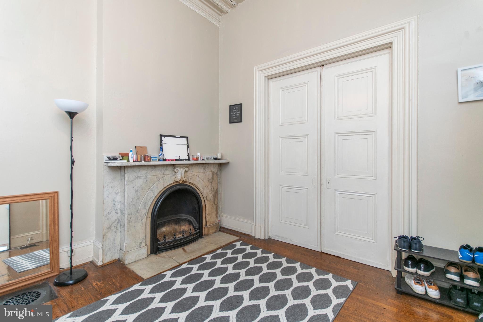 1807 Spruce Street, Unit 1F Philadelphia, PA 19103 - Photo 4 of 12 a bedroom with a bed and a fireplace