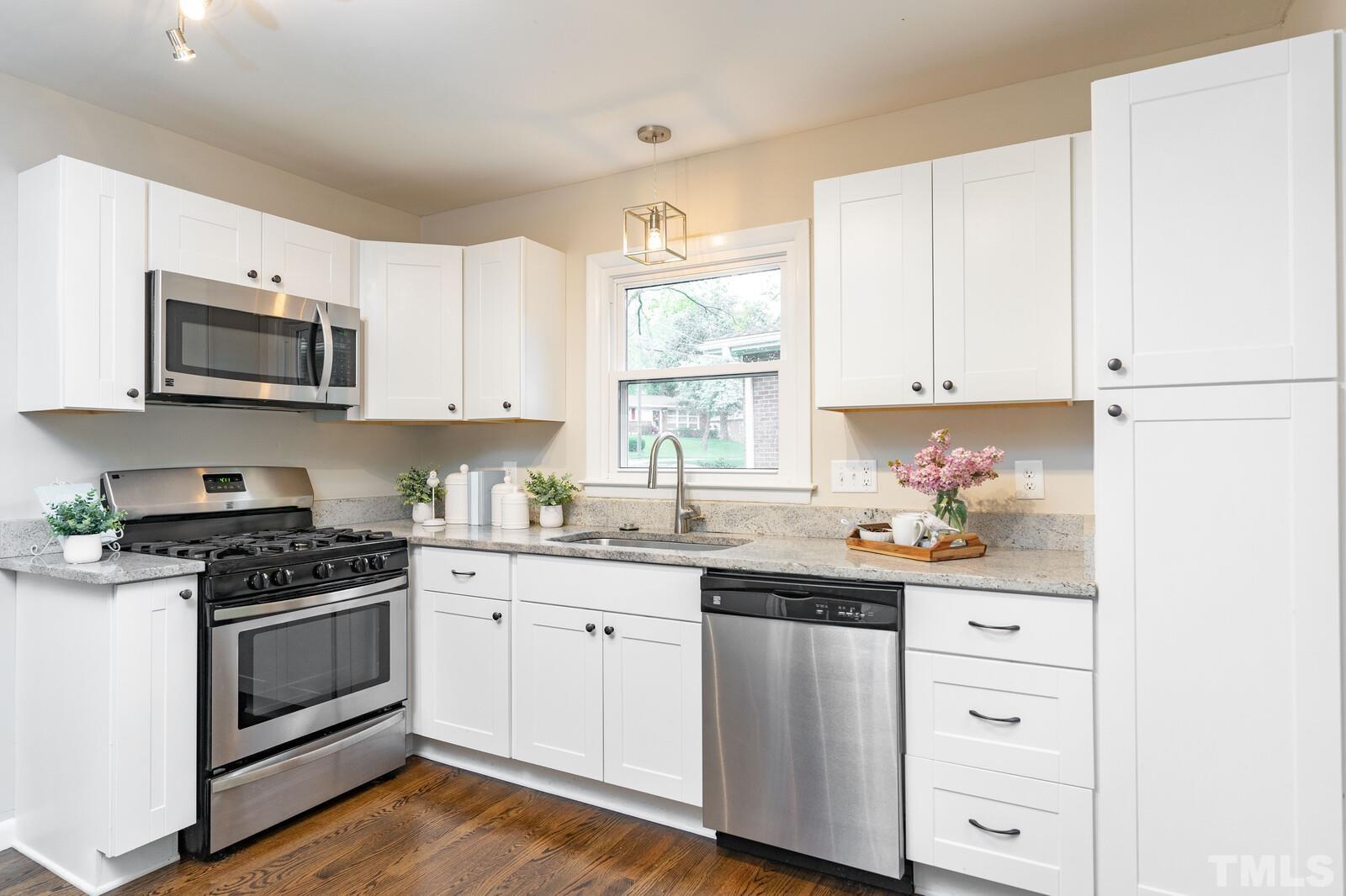 904 Friar Tuck Road Raleigh, NC 27610 - Photo 4 of 13 a kitchen with granite countertop white cabinets and white appliances