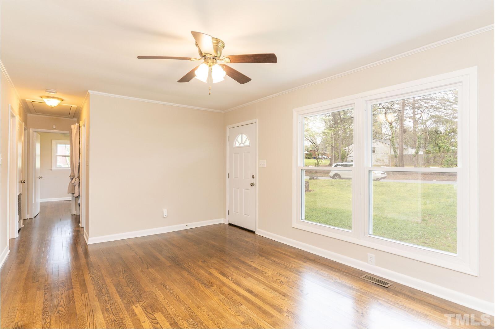 904 Friar Tuck Road Raleigh, NC 27610 - Photo 6 of 13 a view of an empty room with wooden floor and a window
