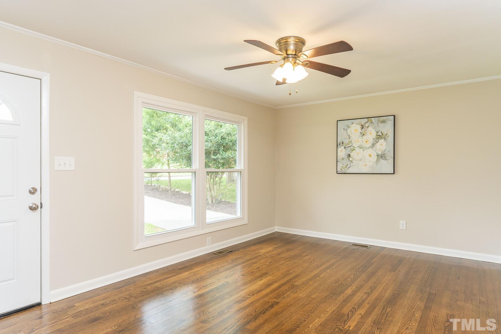 904 Friar Tuck Road Raleigh, NC 27610 - Photo 7 of 13 a view of an empty room with wooden floor and a window