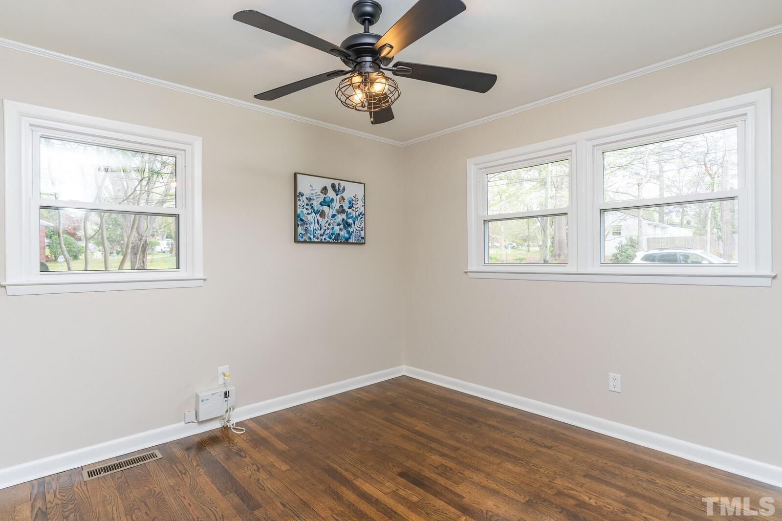904 Friar Tuck Road Raleigh, NC 27610 - Photo 8 of 13 wooden floor in an empty room with a window