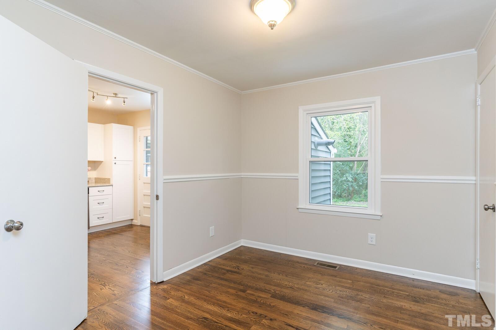 904 Friar Tuck Road Raleigh, NC 27610 - Photo 10 of 13 an empty room with wooden floor and a window