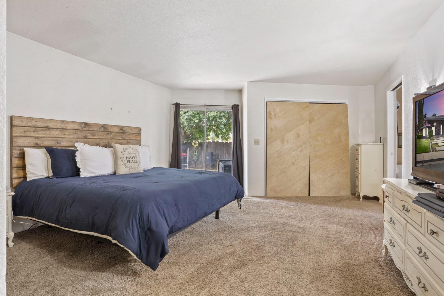 1631 North Johnson Road Turlock, CA 95382 - Photo 24 of 38 a bedroom with a bed and a flat screen tv