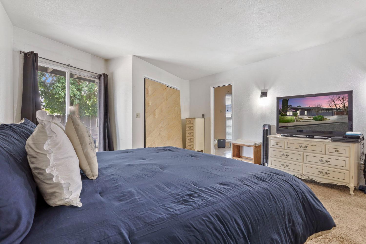 1631 North Johnson Road Turlock, CA 95382 - Photo 25 of 38 a bedroom with a bed tv and window