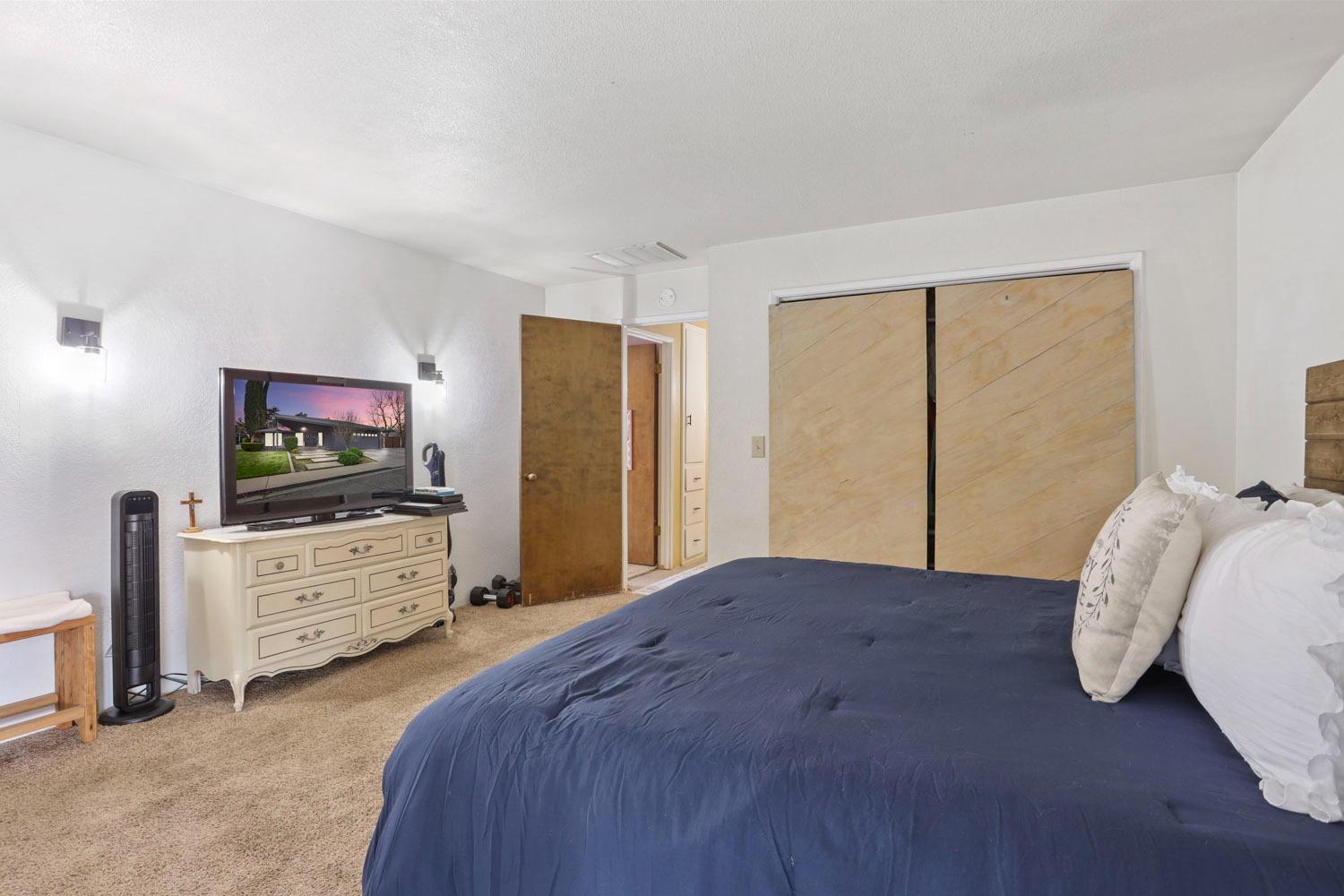 1631 North Johnson Road Turlock, CA 95382 - Photo 26 of 38 a bedroom with a bed and flat screen tv