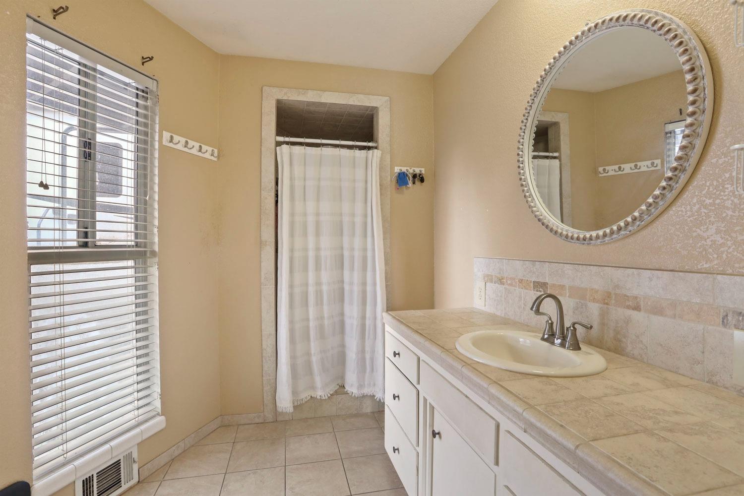 1631 North Johnson Road Turlock, CA 95382 - Photo 27 of 38 a bathroom with a sink and a mirror