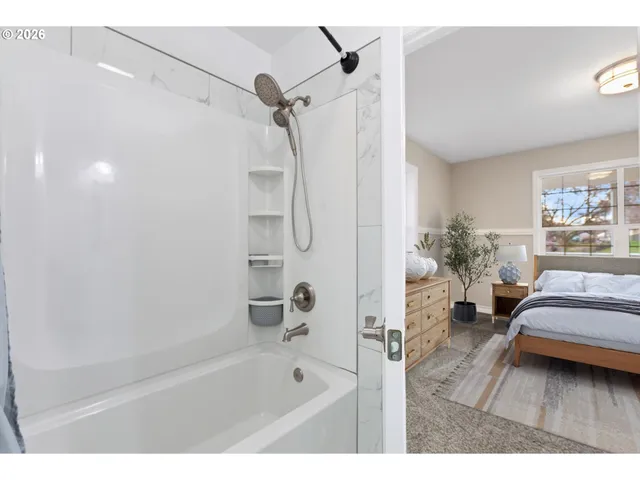 a en suite bathroom with a tub sink and glass door shower