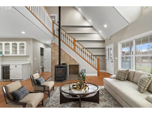 a living room with furniture and a dining table with wooden floor