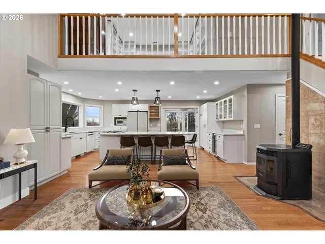 a living room with furniture kitchen view and a chandelier