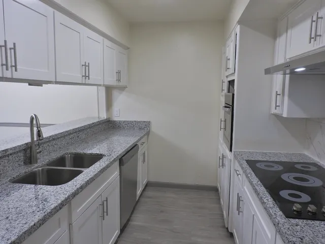 a kitchen with a sink stove top oven and cabinets