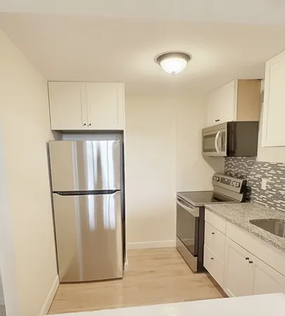 a kitchen with stainless steel appliances a refrigerator sink and microwave