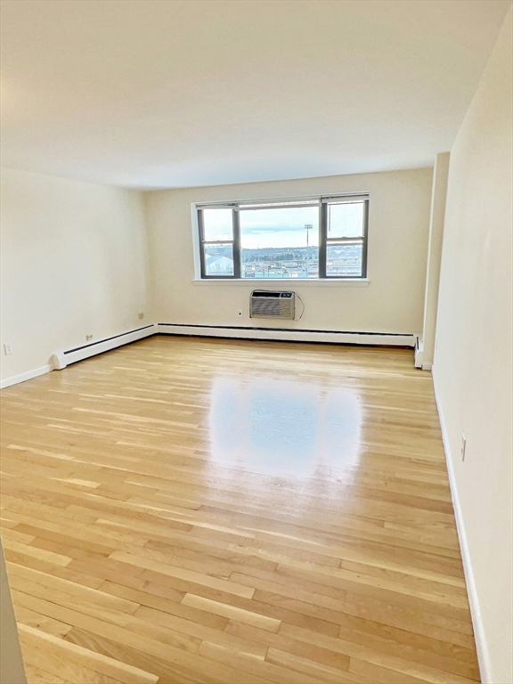 1039 Commonwealth Avenue, Unit 37 Boston, MA 02215 - Photo 3 of 7 a view of an empty room with wooden floor and a window