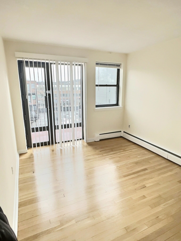 1039 Commonwealth Avenue, Unit 37 Boston, MA 02215 - Photo 5 of 7 an empty room with wooden floor and windows