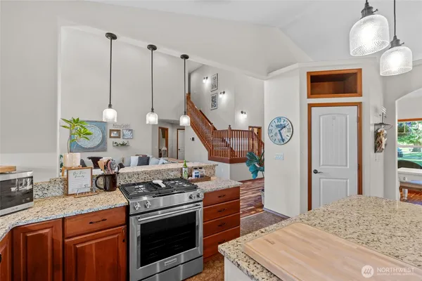 a kitchen with stainless steel appliances granite countertop a stove a sink and a wooden floors