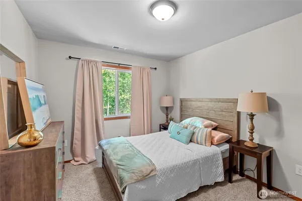 a bedroom with a bed a flat screen tv and a window