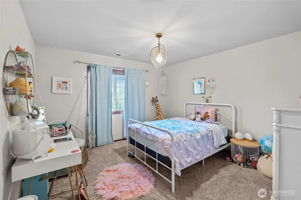 a bedroom with a bed and a chandelier