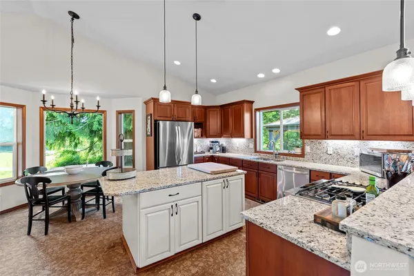 a kitchen with stainless steel appliances granite countertop sink stove and refrigerator